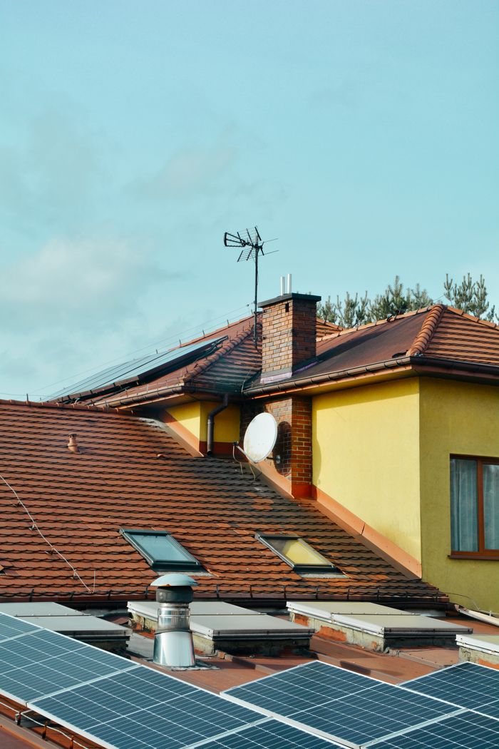 Yellow building with solar panels and antennas on rooftop in Poland. Eco-friendly technology.
